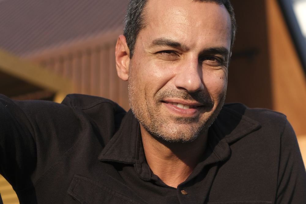 Felipe Savassi em frente a uma construção modular